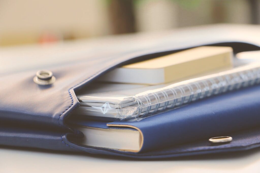 Close-up of a stylish blue portfolio containing various notebooks, creating an organized office look.